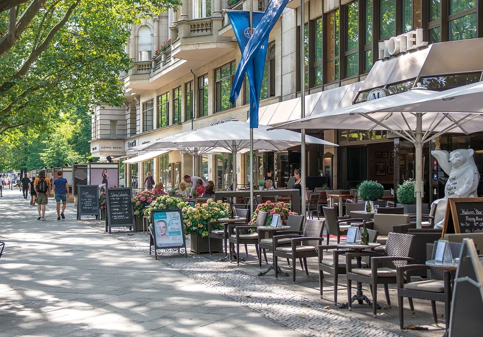 Baumgesäumter Gehweg am Berliner Kurfürstendamm mit Straßencafés