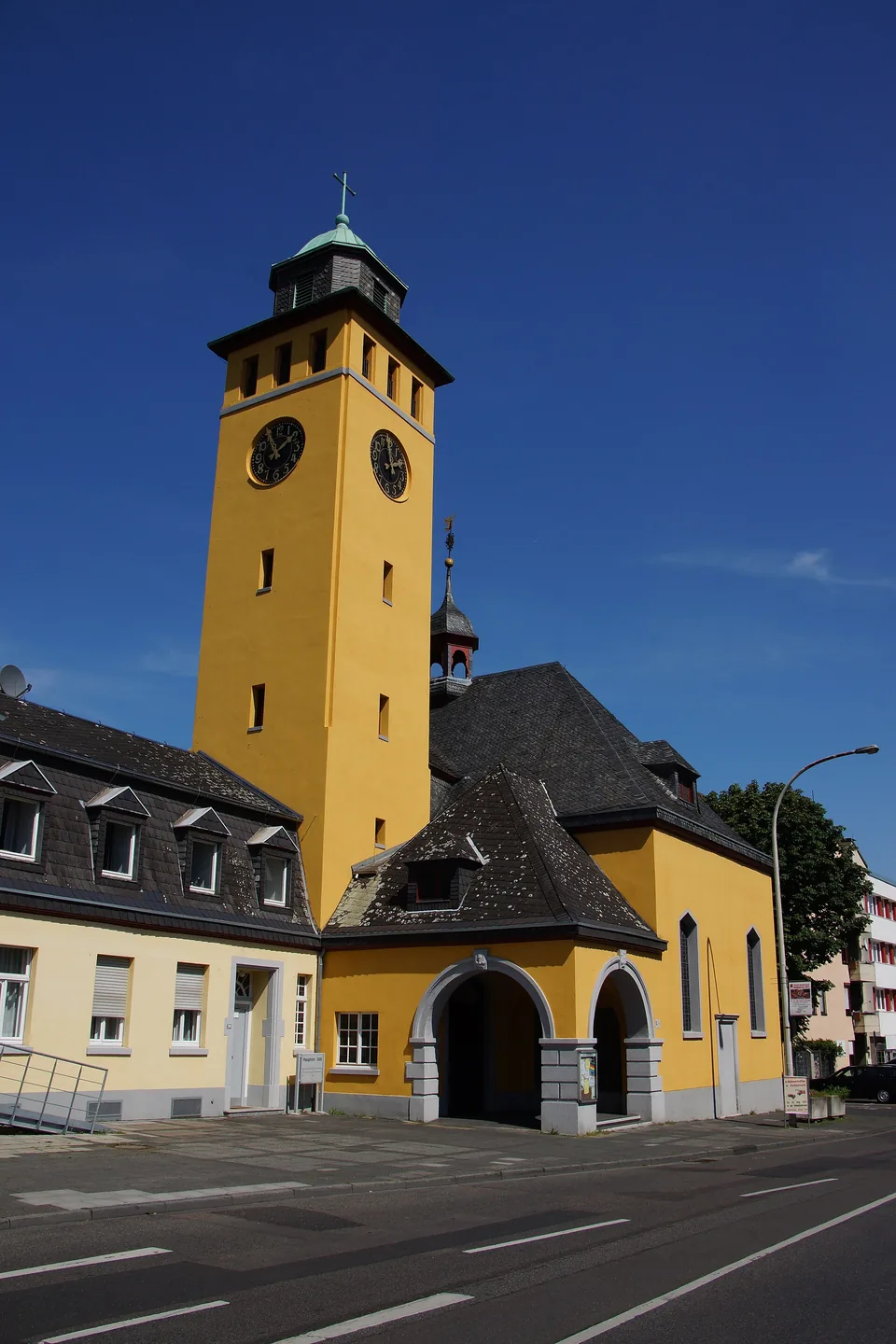Gelber Turm der evangelischen Kirche in Frechen vor blauem Himmel
