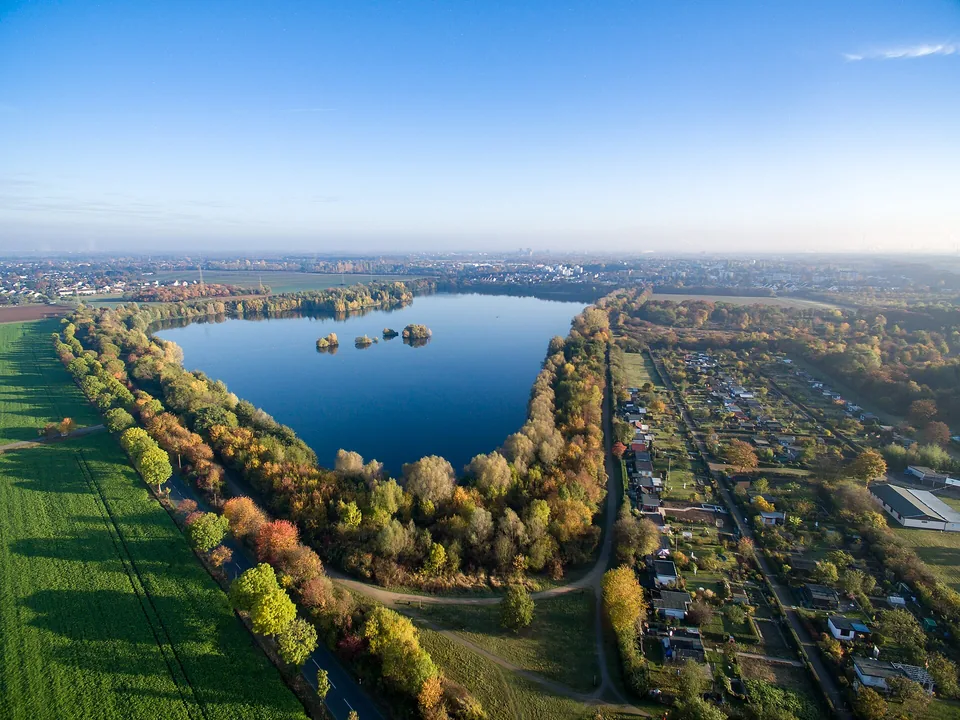 Luftaufnahme des Pescher Sees in Köln mit herbstlichen Bäumen