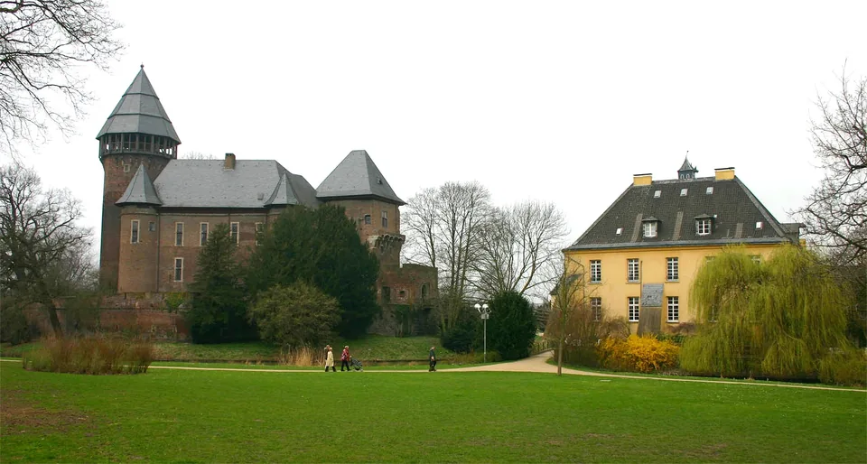 Burg Linn in Krefeld mit Türmen, Wiesen und Bäumen