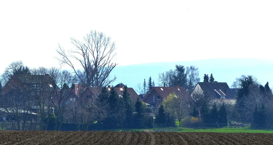 Dächer und Gärten in Titz hinter einer grünen Wiese