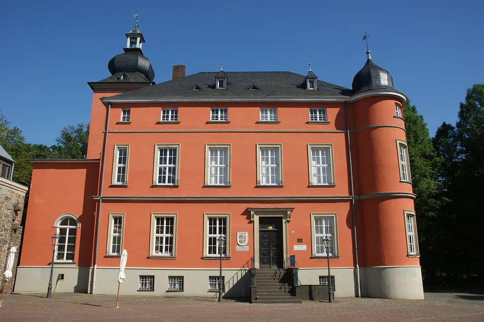 Rote Fassade von Burg Wissem in Troisdorf mit zwei Ecktürmen