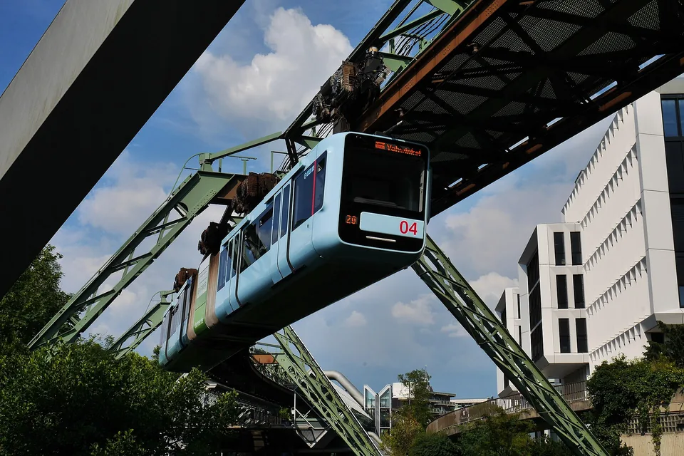 Blaue Wuppertaler Schwebebahn an ihrer erhöhten Fahrstrecke